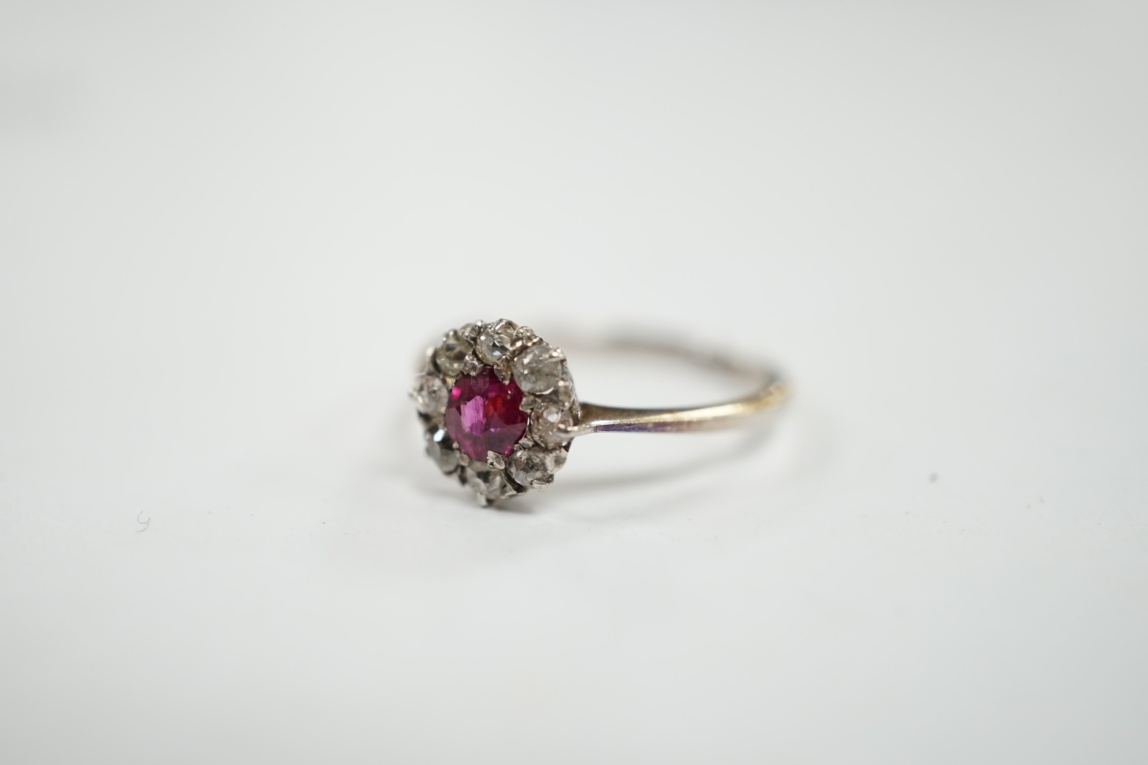 A 1940's 18ct white metal, ruby and diamond set circular cluster ring, size N/O, gross weight 1.9 grams. Condition - fair